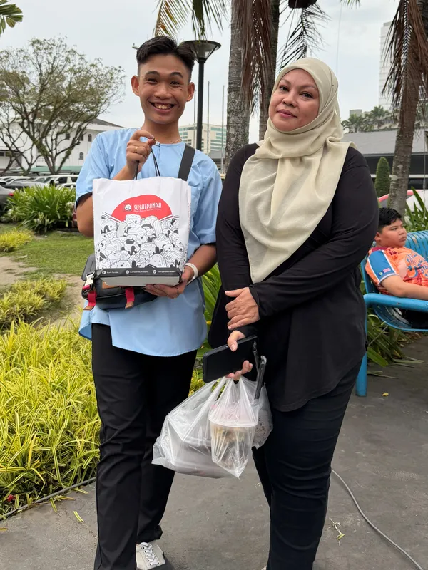 A Sushi Panda crew member shares a Care Box with a member of the public